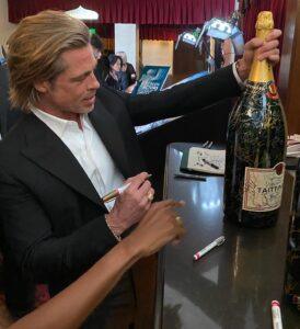 Hollywood actor Brad Pitt signing a large bottle of Taittinger Champagne at the 2020 SAG Awards